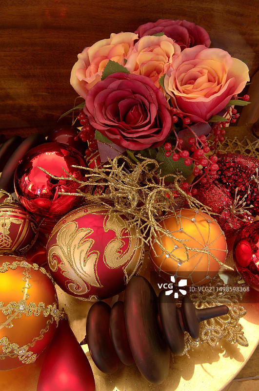 金色盘子上摆放着华丽的圣诞饰品和人造玫瑰图片素材