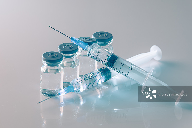 蓝色背景下针管和疫苗瓶图片素材