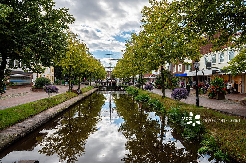 小镇上的宁静运河，两旁商店和鲜花，位于德国下萨克森州图片素材