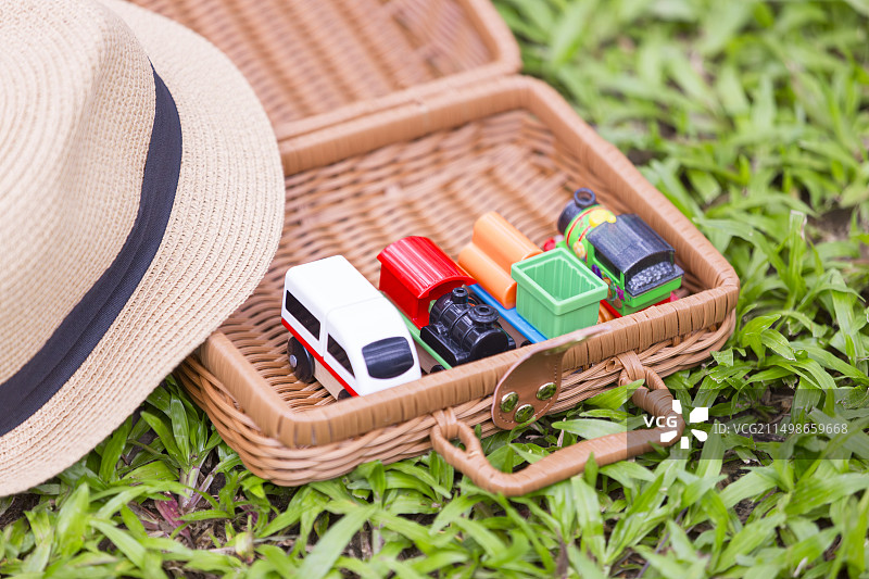 草地上装着玩具的儿童手提行李箱图片素材
