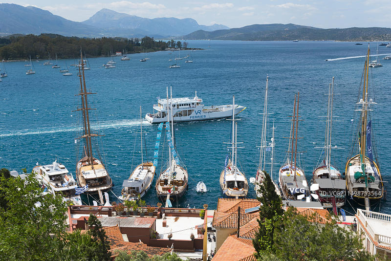 波罗斯岛宁静海港风光，港内停泊着众多帆船和游艇，周围环绕着丘陵和自然风光，波罗斯，萨罗尼克群岛，伯罗奔尼撒，希腊，欧洲图片素材