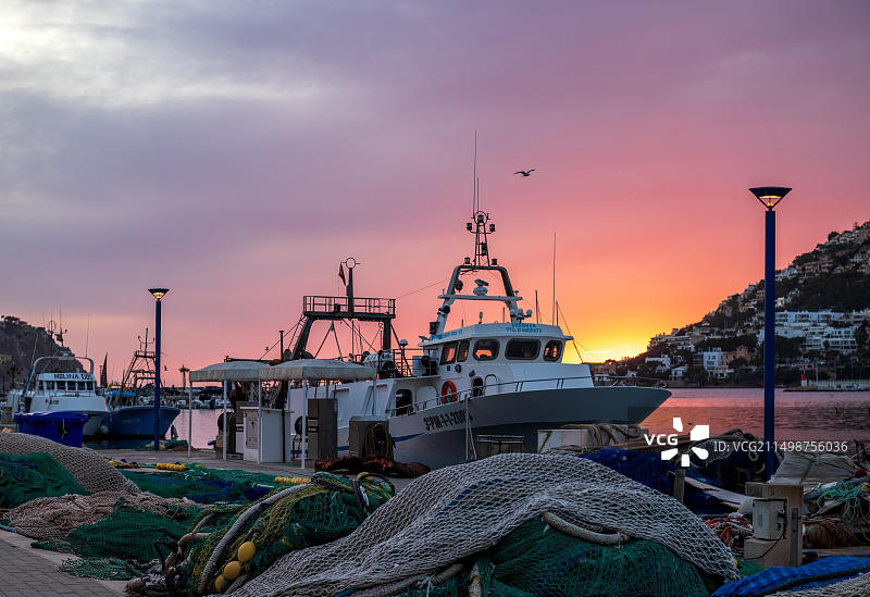 西班牙马略卡岛安德拉奇港的日落渔船和渔网图片素材