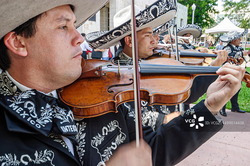 佛罗里达州迈阿密海滩柯林斯公园墨西哥五月五节庆祝活动，墨西哥流浪乐队音乐家演奏小提琴，西班牙裔男子身穿民族服装头戴墨西哥帽图片素材