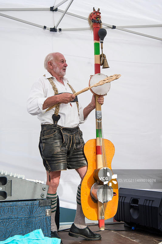 穿着巴伐利亚传统服装、在德国巴伐利亚菲森啤酒节上演奏贝斯的年长音乐家图片素材