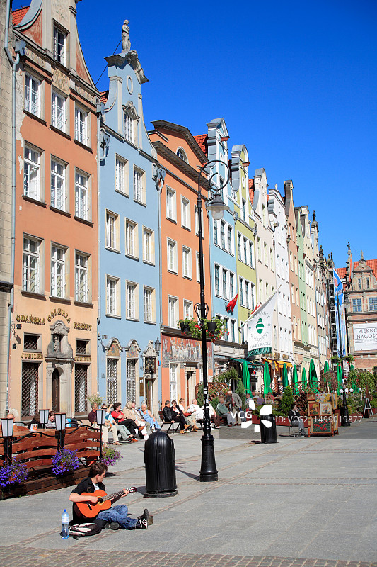 街头音乐家坐在格但斯克老城区演奏吉他图片素材
