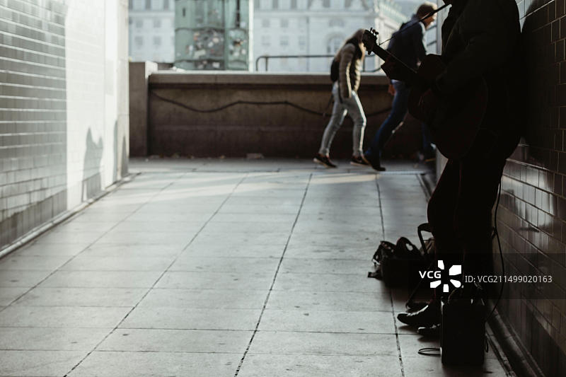地下通道里拿着吉他，催促游客的街头音乐人图片素材