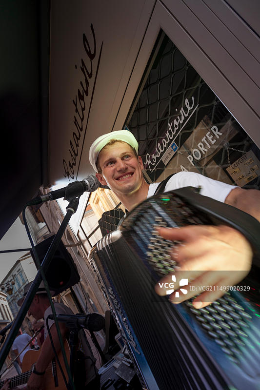 音乐节期间在贝尔热拉克街头演奏手风琴的街头音乐家图片素材