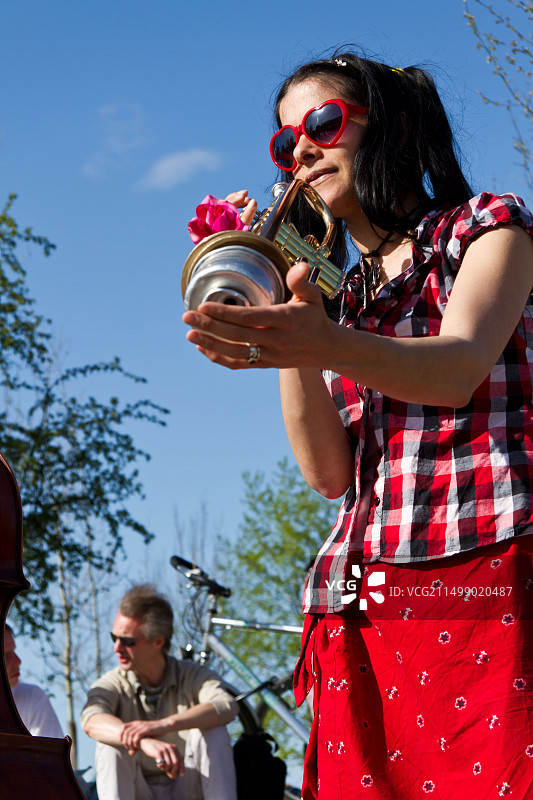 德国柏林，柏林墙公园的年轻街头音乐家用小号演奏图片素材