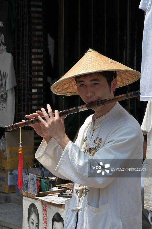 中国广西阳朔：店主吹奏长笛图片素材