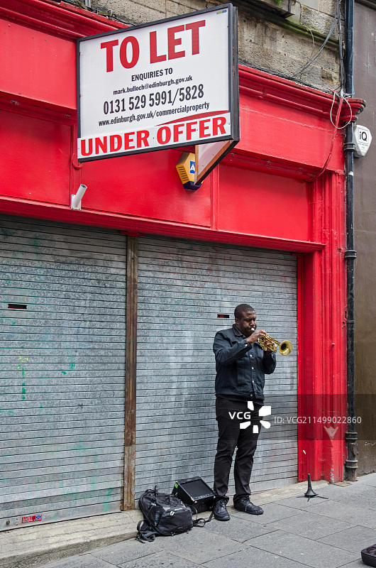 苏格兰爱丁堡Cockburn街店铺外的爵士乐街头艺人图片素材