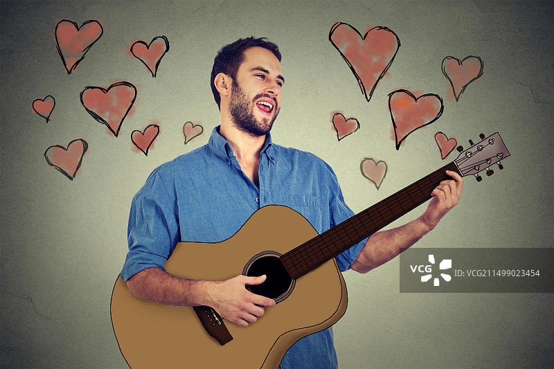 深情的英俊音乐家弹吉他唱歌的年轻胡须男人像图片素材