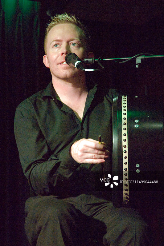 在舞台上演奏爱尔兰鼓的传统爱尔兰音乐家垂直特写图片素材