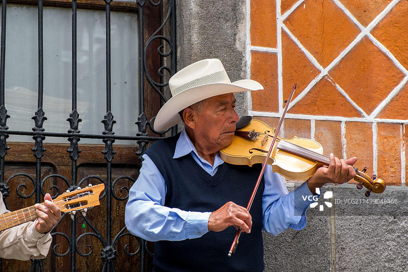 墨西哥普埃布拉街头演奏传统小提琴音乐的男子图片素材