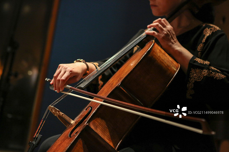 大提琴演奏者手部与琴弓特写图片素材