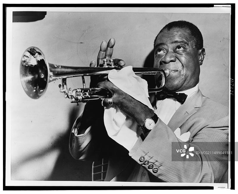 路易斯·阿姆斯特朗演奏小号的头像照，1953年图片素材