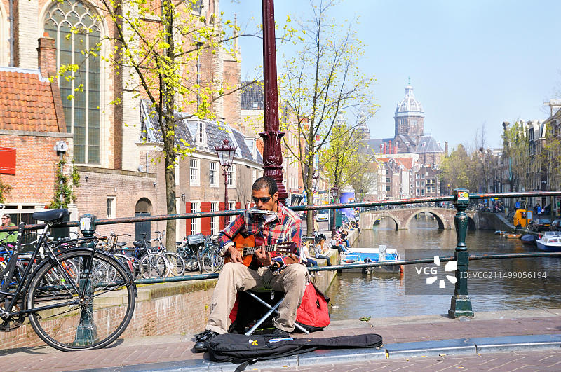 阿姆斯特丹红灯区：街头艺人在温暖的春日弹奏吉他和口琴图片素材