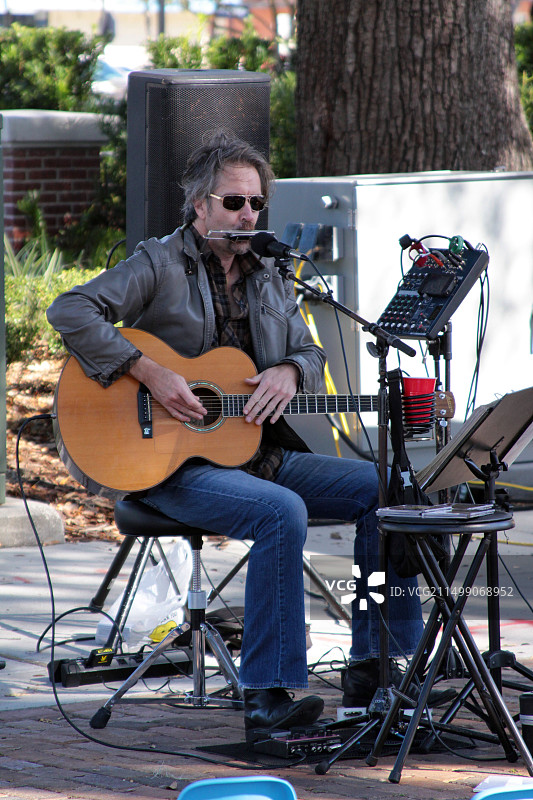 乐手在公园弹奏吉他与口琴图片素材