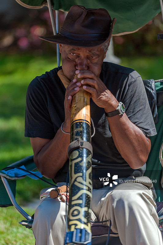 在加利福尼亚州圣地亚哥巴尔博亚公园演奏迪吉里杜管的乐师图片素材