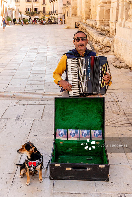 意大利西西里锡拉库萨奥尔蒂贾街头音乐家和宠物狗图片素材