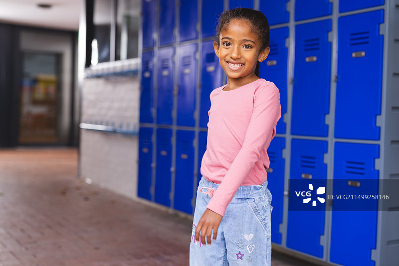 站在蓝色储物柜旁的混血女孩图片素材