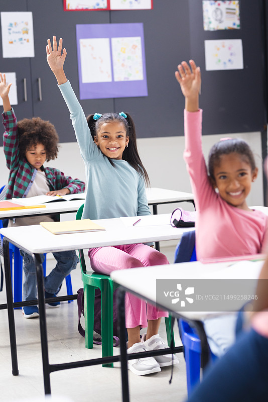 在学校里，多元家庭和孩子们在课堂上举手图片素材