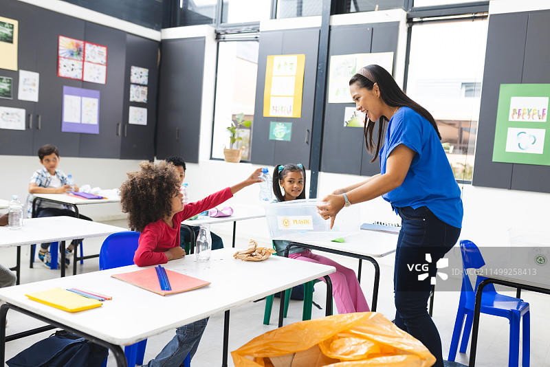 学校里，中年混血老师与学生在教室里一起做回收图片素材