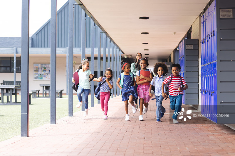 校园里，一群学生在户外走廊奔跑图片素材