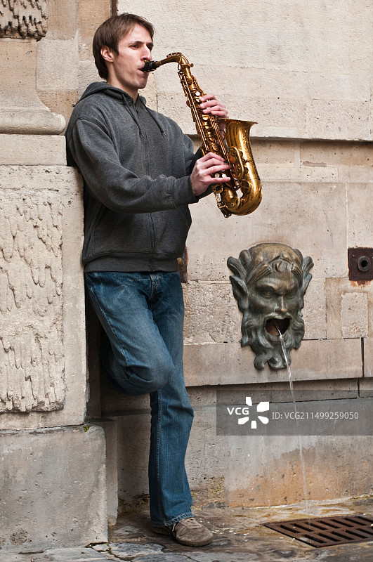 年轻男人在巴黎街头吹萨克斯图片素材