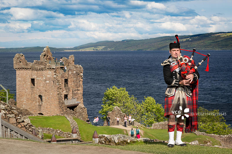 在英国苏格兰高地尼斯湖沿岸厄克特城堡遗址附近演奏风笛图片素材