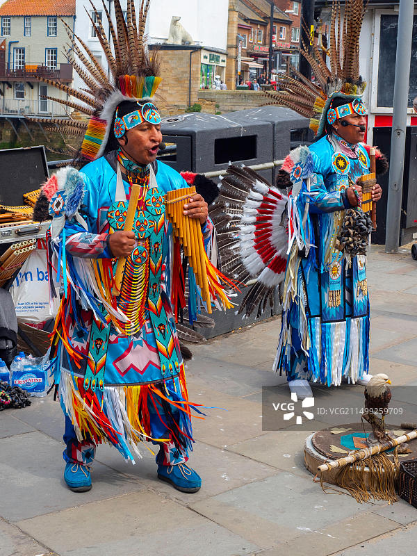 身着南美服饰的街头音乐家在惠特比镇中心演奏排箫图片素材