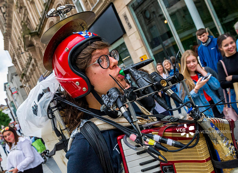 一名男子在利物浦繁忙的商业街上用多种乐器进行街头表演图片素材