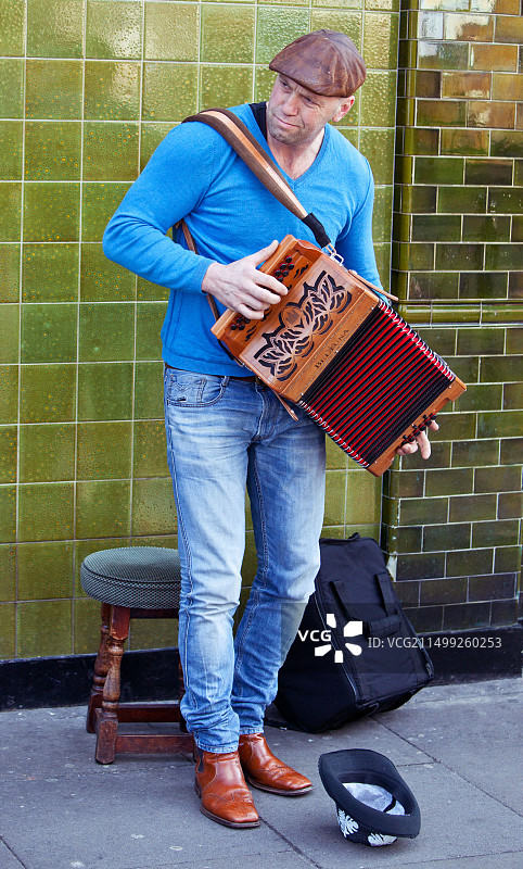 一位在英国伦敦哥伦比亚路花卉市场演奏手风琴的街头艺人全身像图片素材
