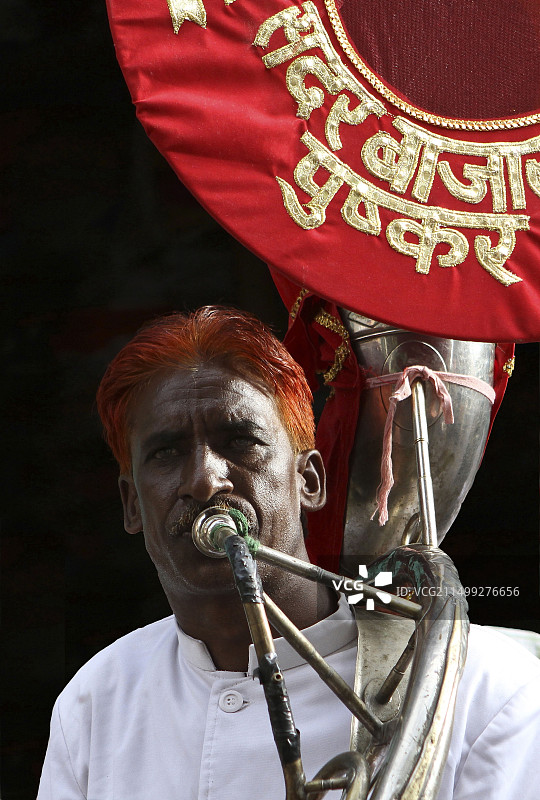 在街头节日里吹喇叭，头发上染着指甲花的印度男人，印度拉贾斯坦邦图片素材