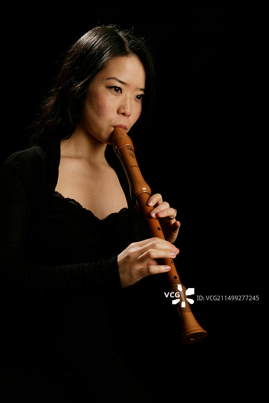 年轻女子演奏中音或高音竖笛图片素材