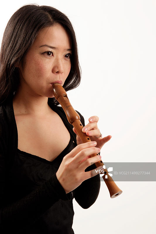 演奏高音或女高音竖笛的年轻女子图片素材