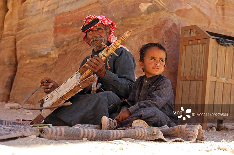 父亲和儿子在约旦佩特拉演奏音乐图片素材