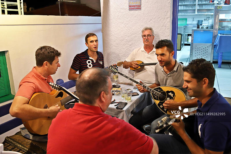 著名的雷贝蒂科音乐家兼歌手吉奥戈斯·辛塔里斯和他的儿子安东尼斯和托多里斯（+朋友们）在斯科派洛斯岛的“Anatoli”小酒馆演奏图片素材