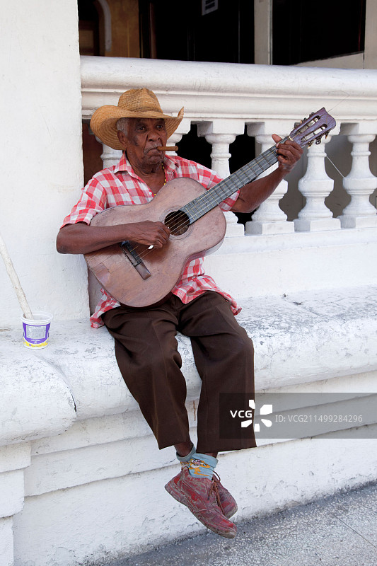 在古巴圣地亚哥抽雪茄的吉他手图片素材
