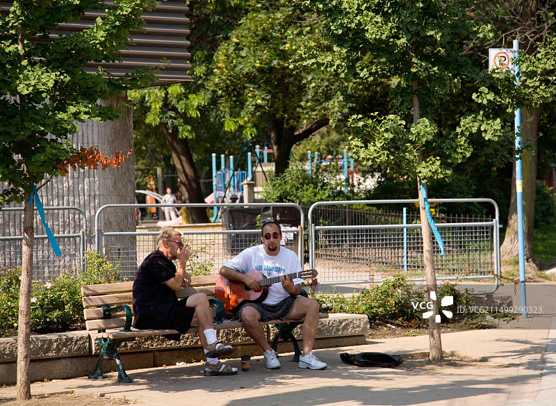 两名户外音乐家在加拿大多伦多肯辛顿市场公园演奏音乐图片素材