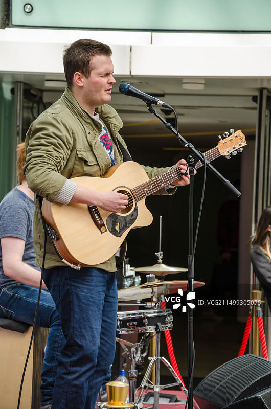 一群人在伦敦牧羊人 bush 韦斯特菲尔德购物中心的“新音乐”舞台上表演。图片素材