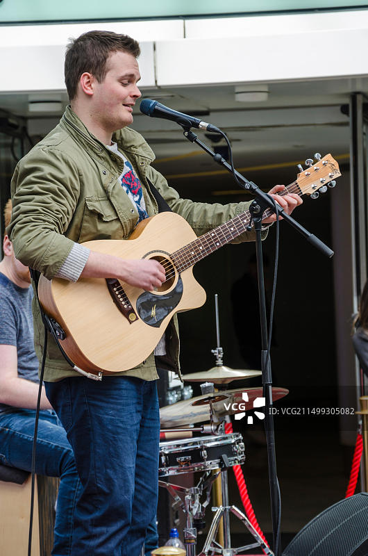 一群人在伦敦牧羊人 bush 韦斯特菲尔德购物中心的“新音乐”舞台上表演。图片素材