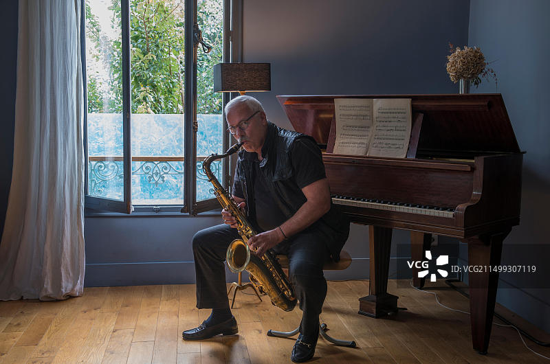 在音乐室里吹萨克斯的年长男人图片素材