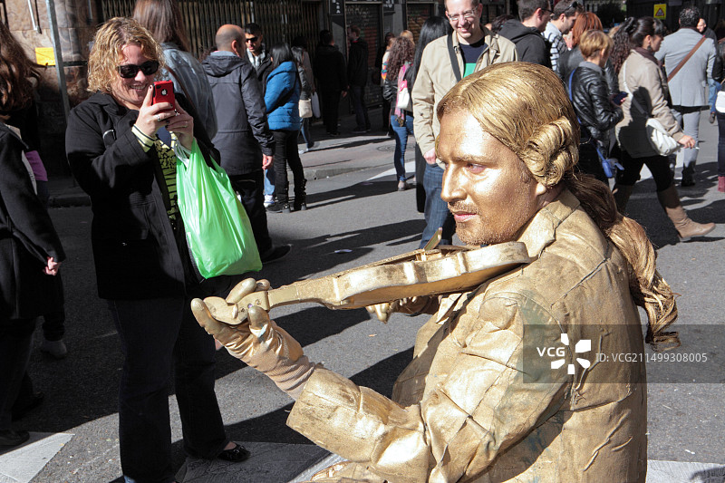 马德里街头的金色人体彩绘雕塑艺人与小提琴图片素材