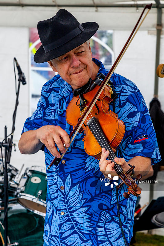 在英国东萨塞克斯郡哈特菲尔德村年度游乐会上演奏小提琴的男子图片素材