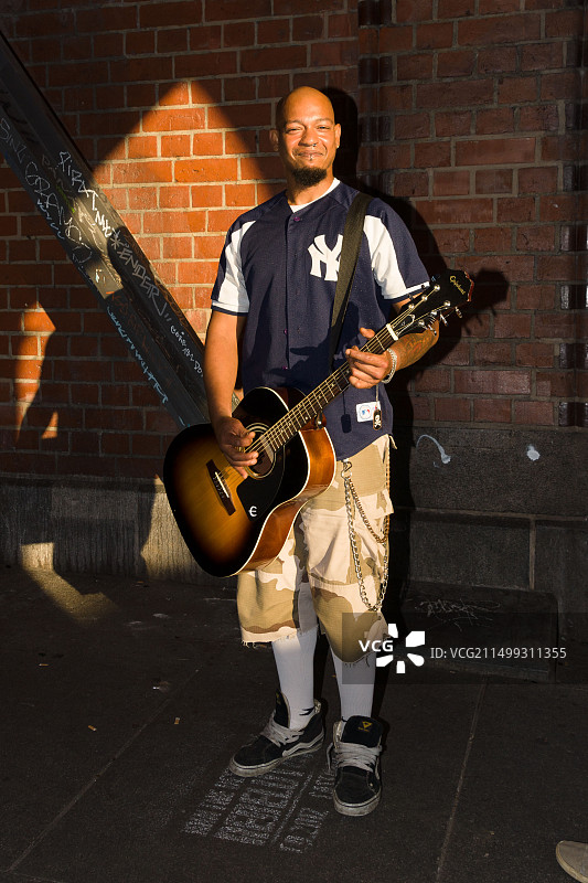 一位街头音乐家，一位抱着吉他的黑人男子，德国柏林图片素材