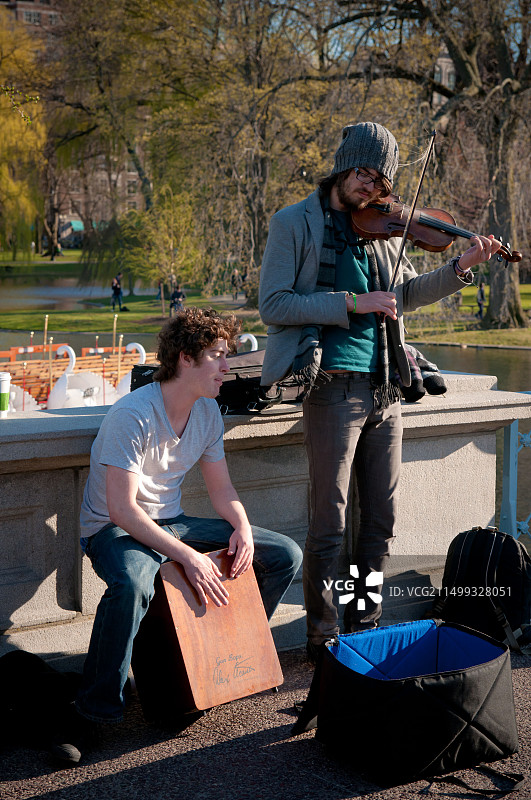 街头音乐家在2011年春季波士顿公共花园的泻湖桥上演奏小提琴图片素材