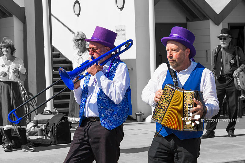 在英国多塞特郡斯瓦尼奇民俗节上，音乐家演奏手风琴和长号，为莫里斯舞蹈者伴奏图片素材