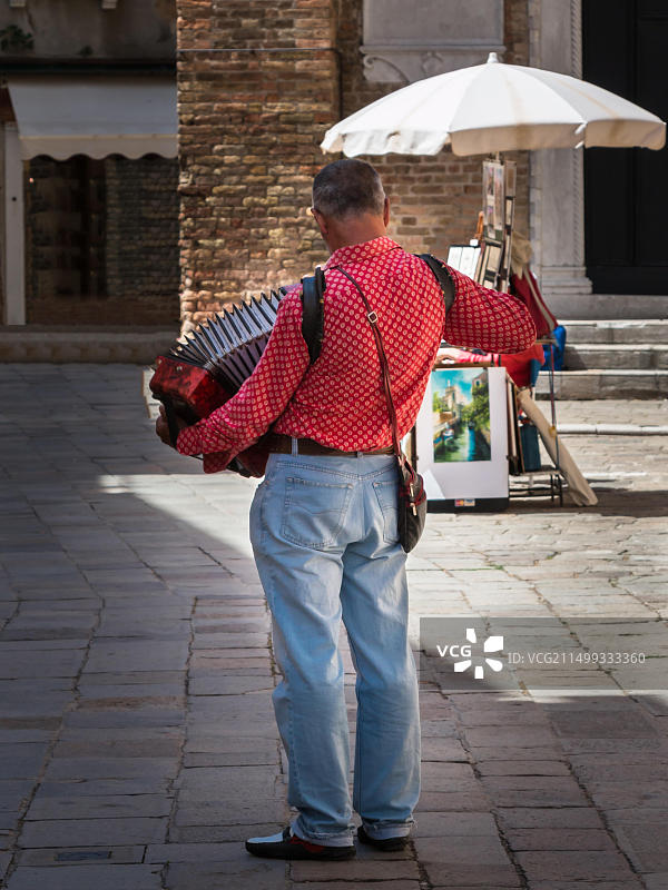 街头音乐人用红色手风琴表演图片素材