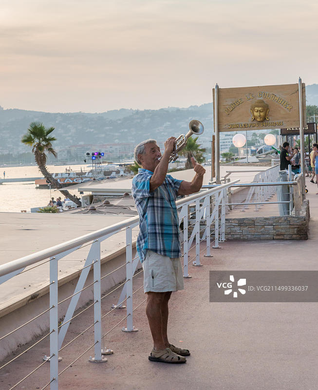 男人在法国胡安莱潘公开演奏萨克斯，该市每年夏天都会举办著名的爵士音乐节图片素材