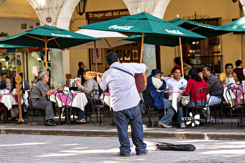 在墨西哥瓦哈卡的历史广场上，一位音乐家在弹吉他图片素材